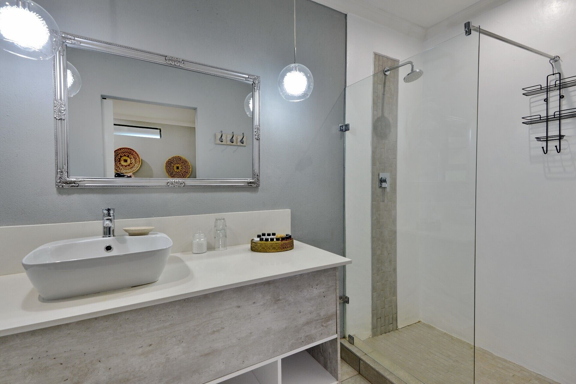 A bathroom with a white sink, a large mirror, and a shower area.