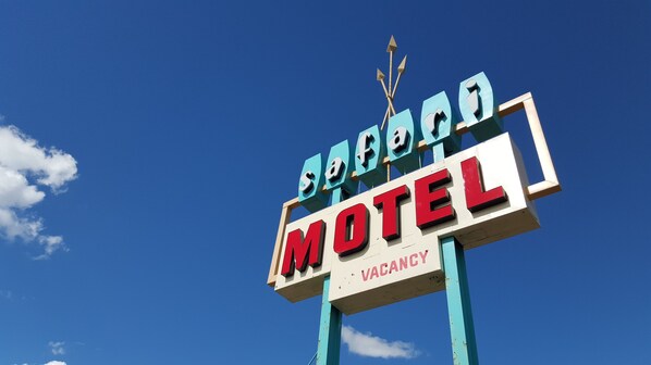 A motel sign with a clear sky in the background.