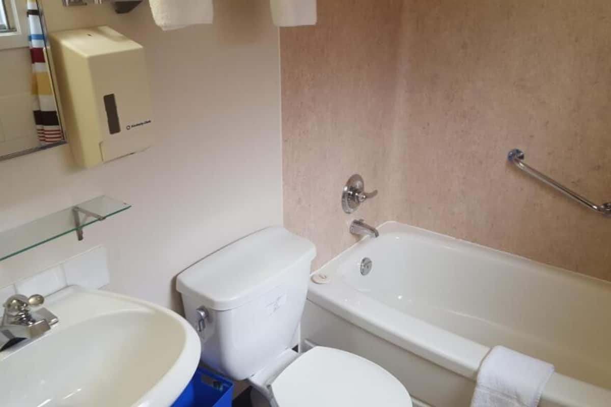 A bathroom with a toilet, sink, and bathtub.
