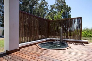 A wooden deck with a hot tub and a bamboo fence. - Rest Chabivin Self Catering (Stellenbosch)