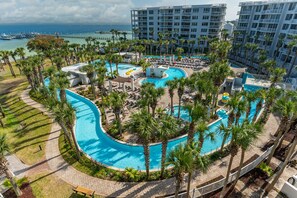 A resort with a large central pool, palm trees, and a marina in the background. - Destin West Resort by Panhandle Getaways (Fort Walton Beach)
