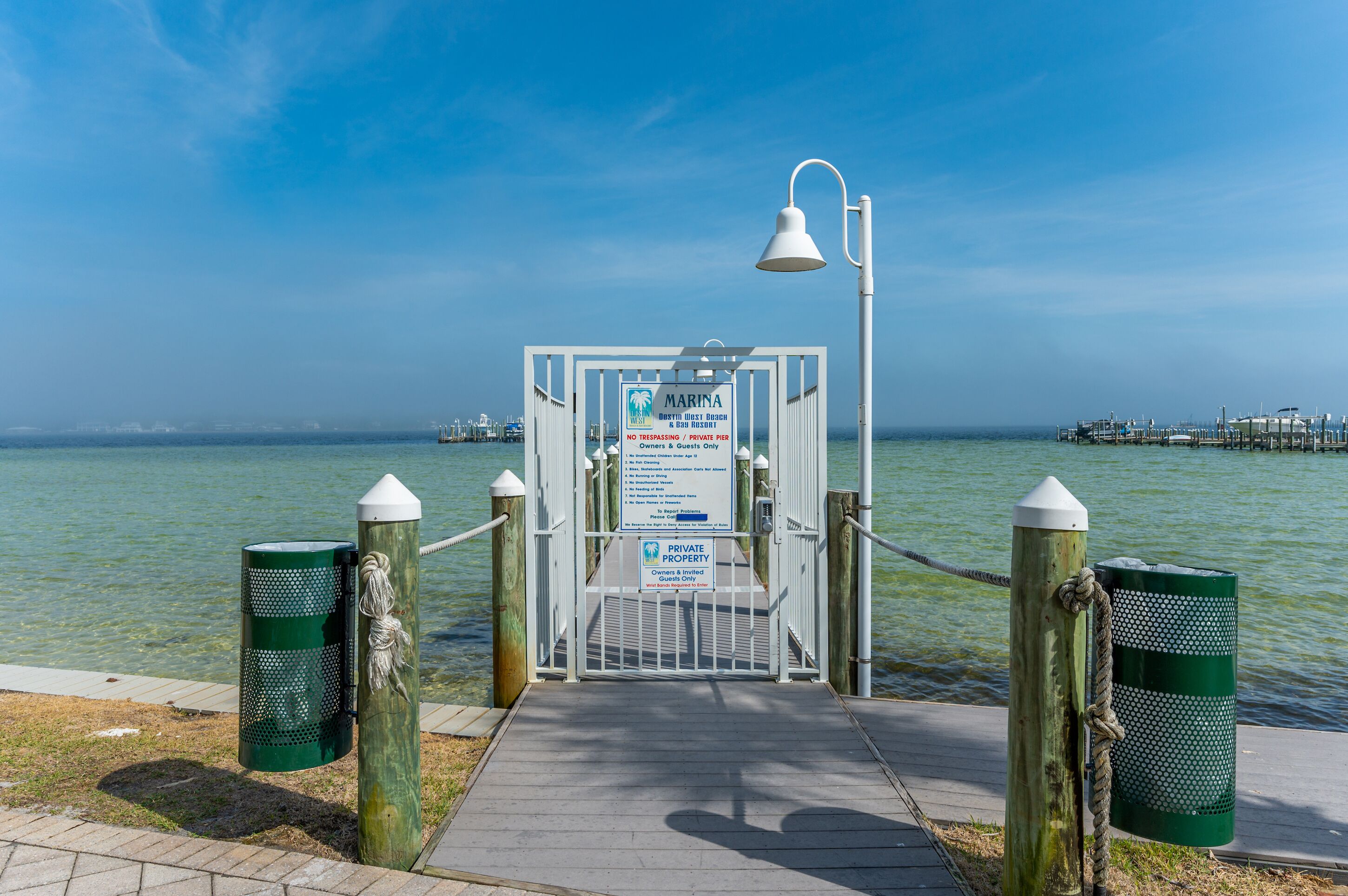 A gated entrance to a marina with a sign indicating private property and no trespassing.