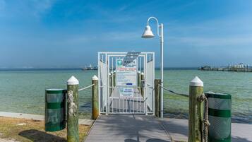 A gated entrance to a marina with a sign indicating private property and no trespassing.
