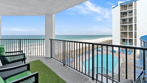 Un balcon avec vue sur la plage et une piscine.