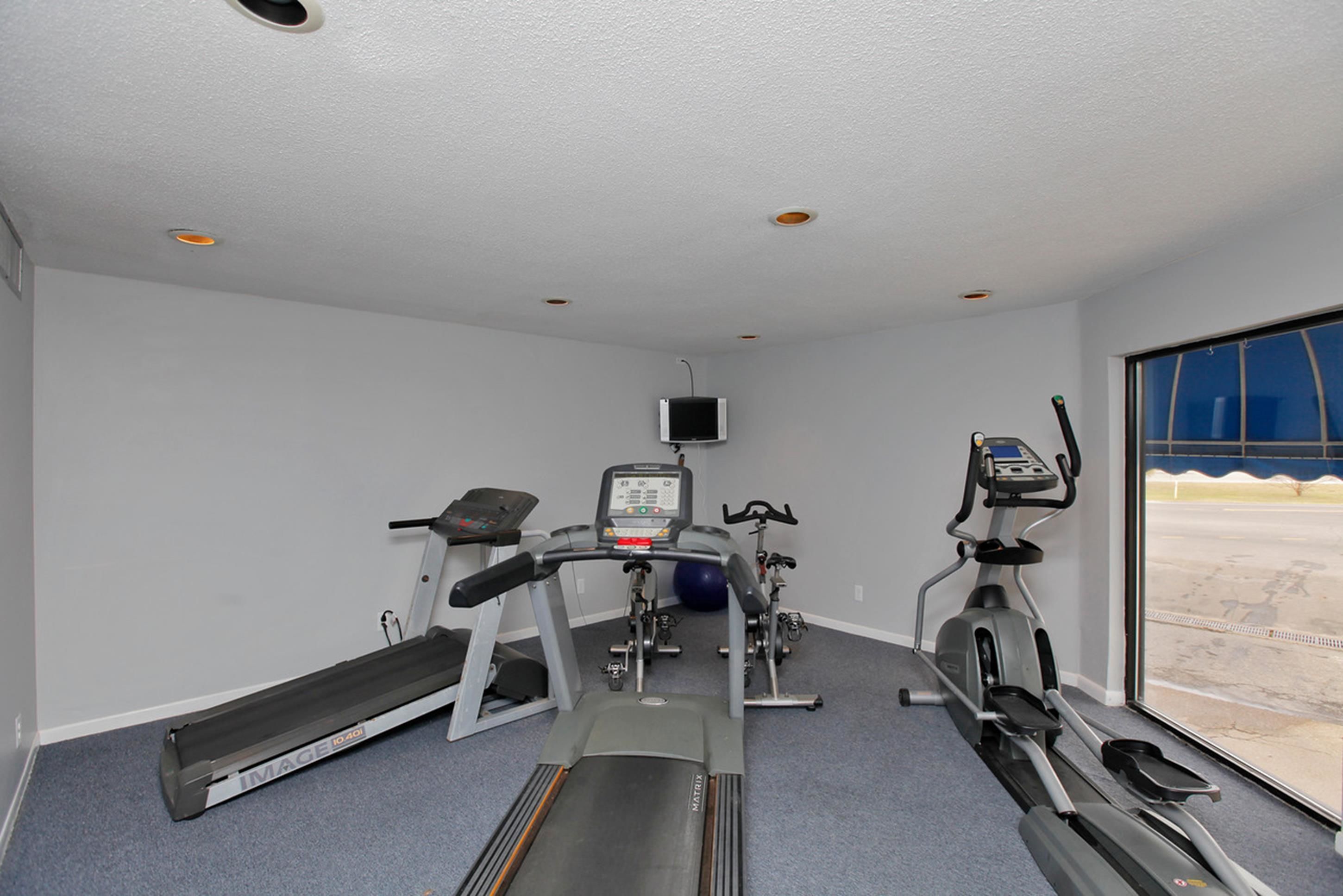 A gym with treadmills, an elliptical, and a stationary bike.