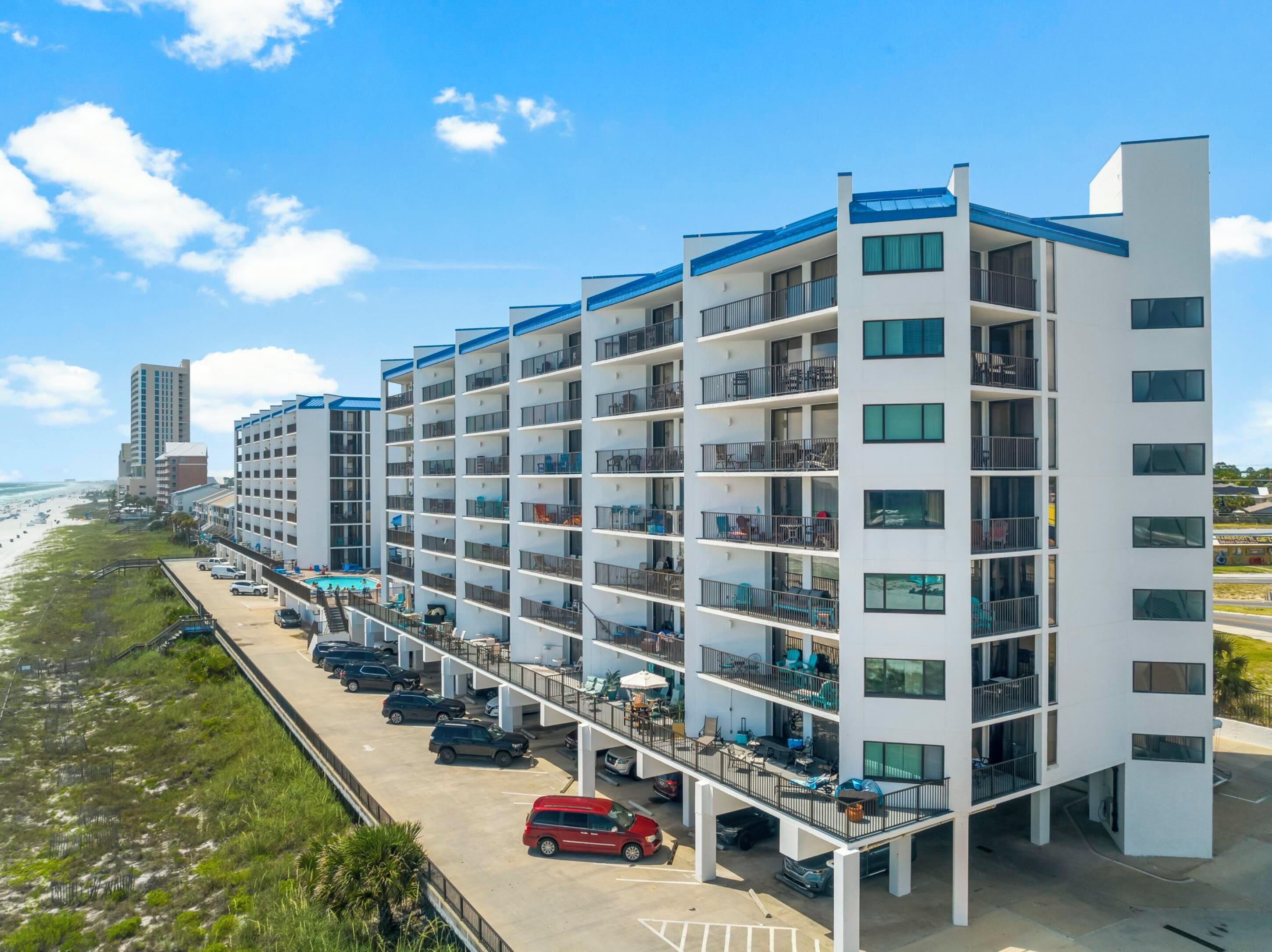 Un hôtel à plusieurs étages doté de balcons, d’un espace piscine et offrant une vue sur la plage.