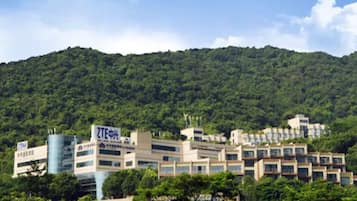 Un complejo hotelero con varias edificaciones, rodeado de colinas verdes y exuberantes.