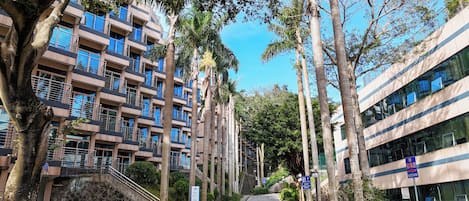 A multi-story hotel with balconies, a central staircase, and a parking sign indicating a 30-meter distance.