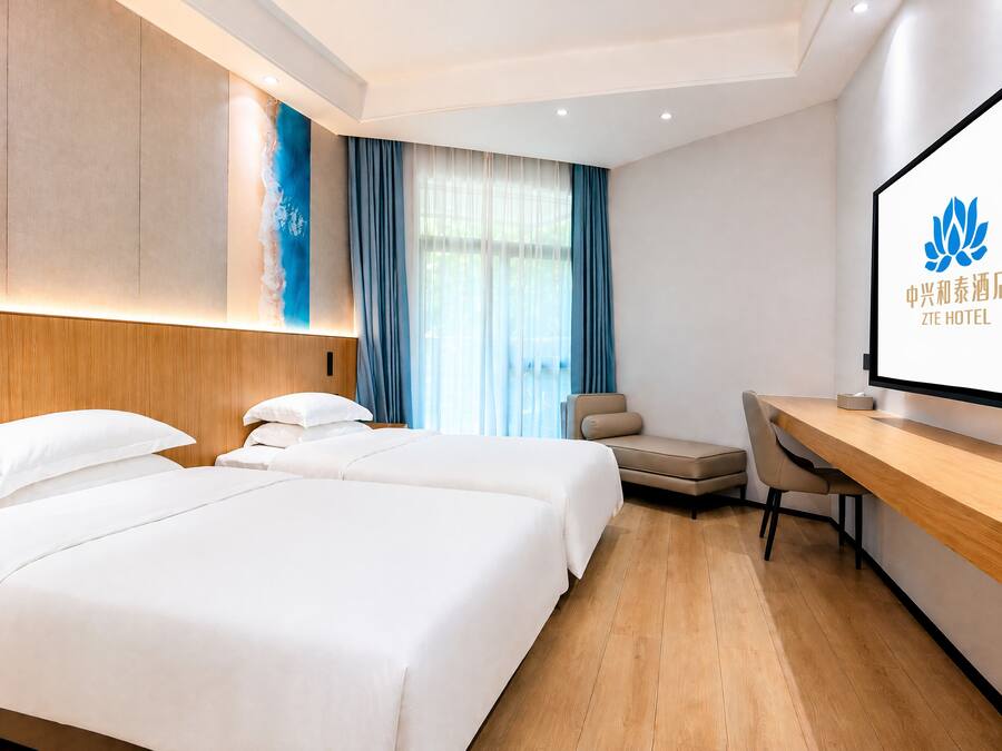 A hotel room with two beds, a desk, a chair, a TV, and a large window with curtains.