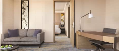 A modern hotel room with a sofa, a desk, and a bed.