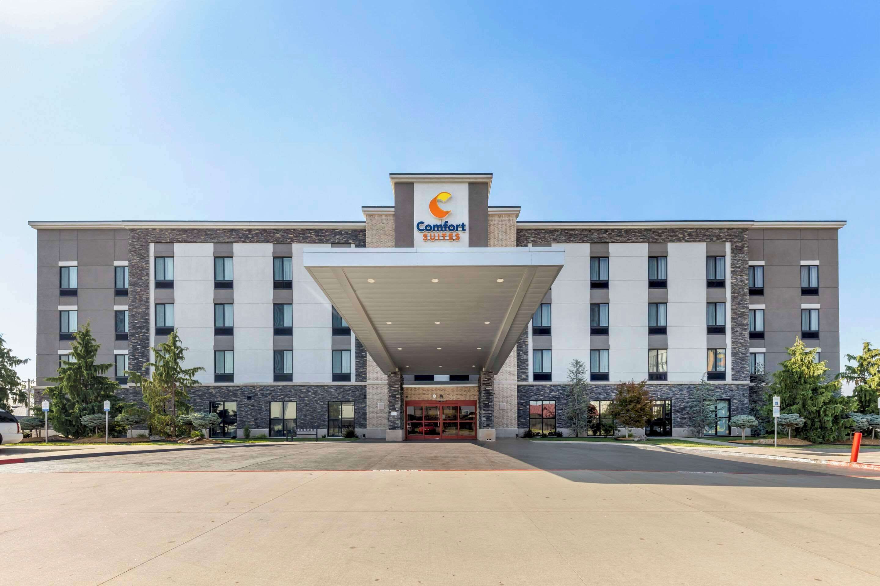 Ein Comfort Suites Hotel mit moderner Fassade, mehreren Stockwerken und einem überdachten Eingang.