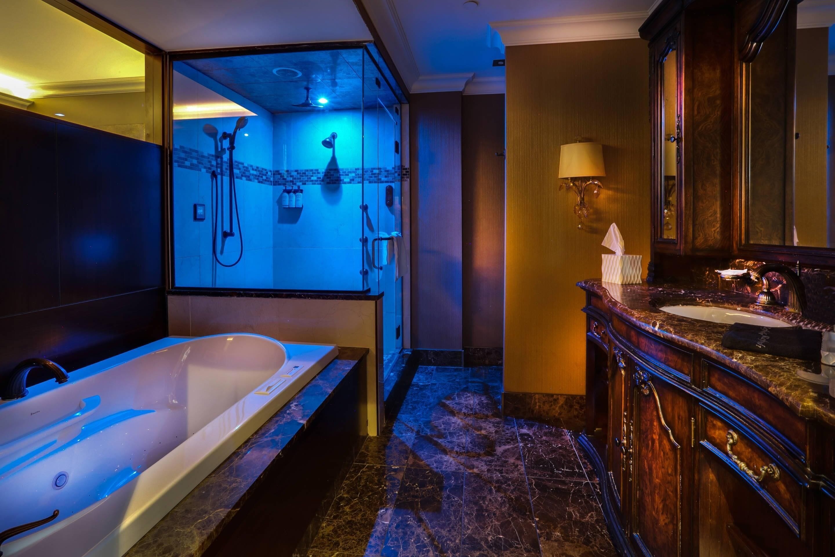 A modern bathroom with a large bathtub, a separate shower area, and a vanity with a mirror.