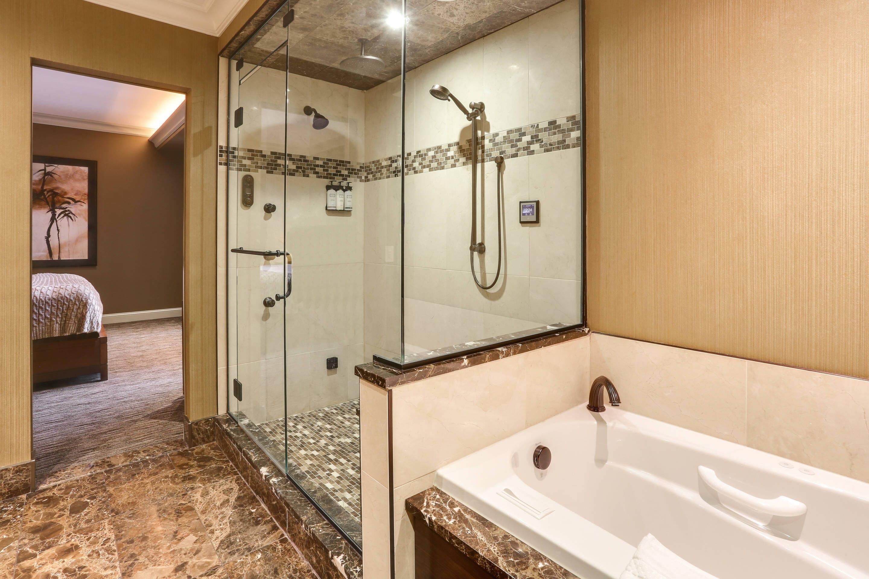 Une salle de bain dotée d’une douche à parois de verre, d’une grande baignoire et d’une œuvre d’art encadrée au mur.