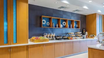 Een moderne keuken met houten kastjes, een aanrecht met etenswaren en decoratieve borden aan de muur.