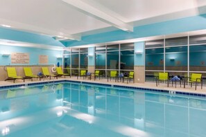 A swimming pool with clear blue water, surrounded by yellow lounge chairs and a blue ceiling. - SpringHill Suites by Marriott Columbia (Columbia)