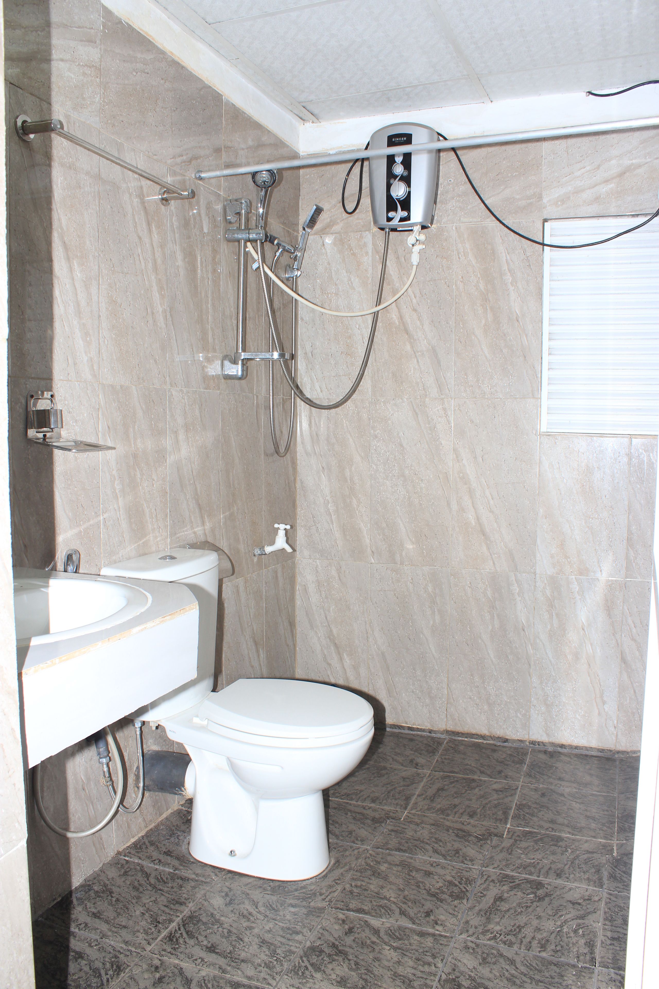 A bathroom with a toilet, sink, and shower.