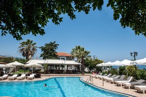 Piscine extérieure, parasols de plage, chaises longues