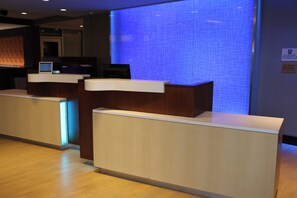 A reception desk with a digital screen, a blue illuminated wall, and a sign indicating no pets are allowed. - Fairfield Inn & Suites by Marriott Bowling Green (Bowling Green)