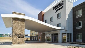 A Fairfield Inn & Suites Marriott hotel with a modern design, featuring a prominent entrance and a covered outdoor area.