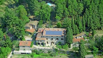 Vue aérienne d’un quartier résidentiel avec de nombreuses maisons, dont une dont le toit est équipé de panneaux solaires.