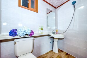 Une salle de bain avec des toilettes, un lavabo et une douche.