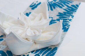 A white bowl with a floral design placed on a blue and white patterned fabric.
