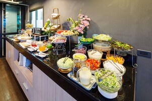 Un buffet proposant une variété de plats et un vase rempli de fleurs.