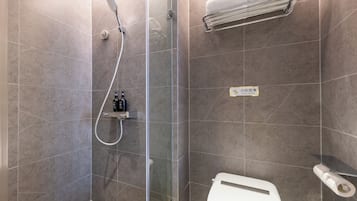 Une salle de bain moderne avec une douche à parois de verre, des toilettes et un porte-serviettes.