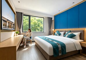 Una habitación de hotel con una cama grande, un escritorio y una ventana con cortinas.