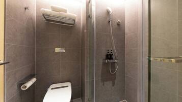 A modern bathroom with a glass-enclosed shower, a toilet, and a towel rack.