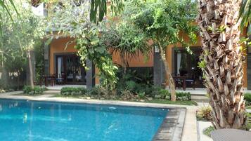 Una piscina al aire libre, tumbonas