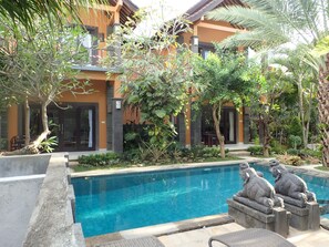 Una piscina al aire libre, sillones reclinables de piscina