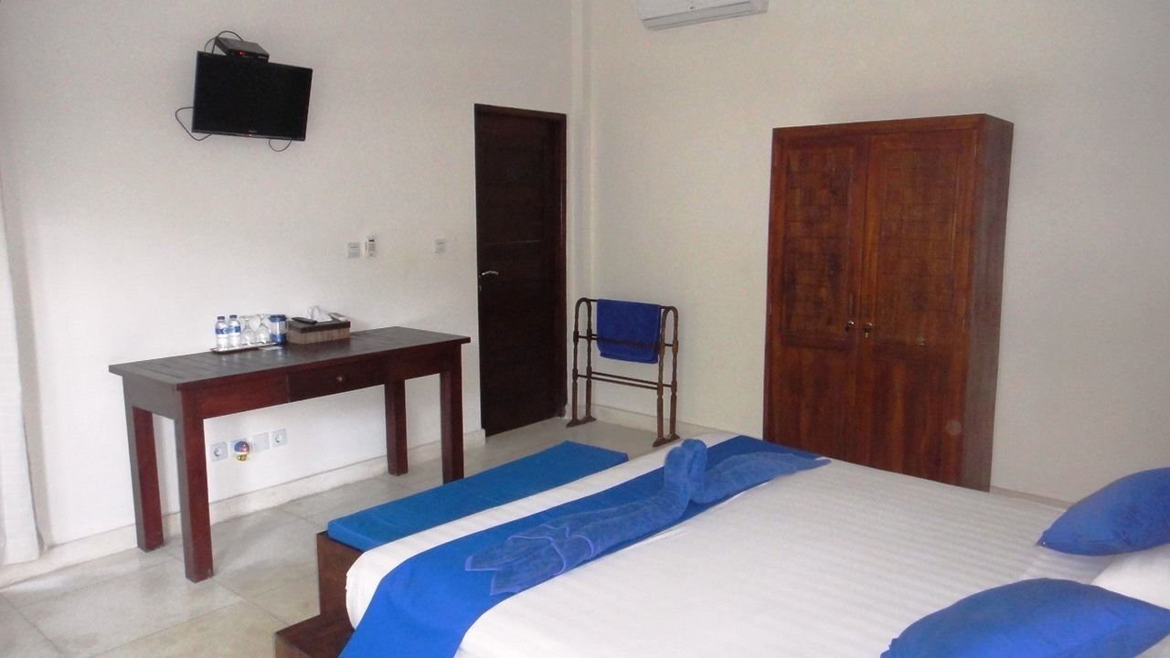 Un dormitorio con cama, escritorio, armario y silla.