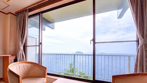 Un balcone con vista sul mare, due sedie e un tavolo.