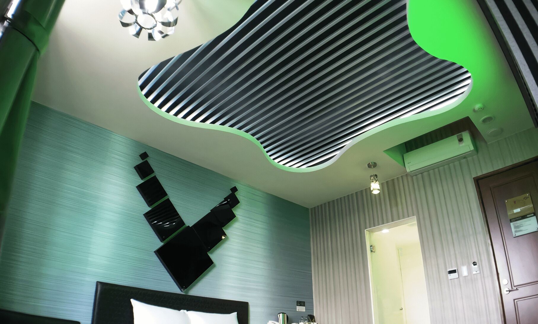 A modern bathroom with a unique ceiling design, a large mirror, and a door leading to another room.