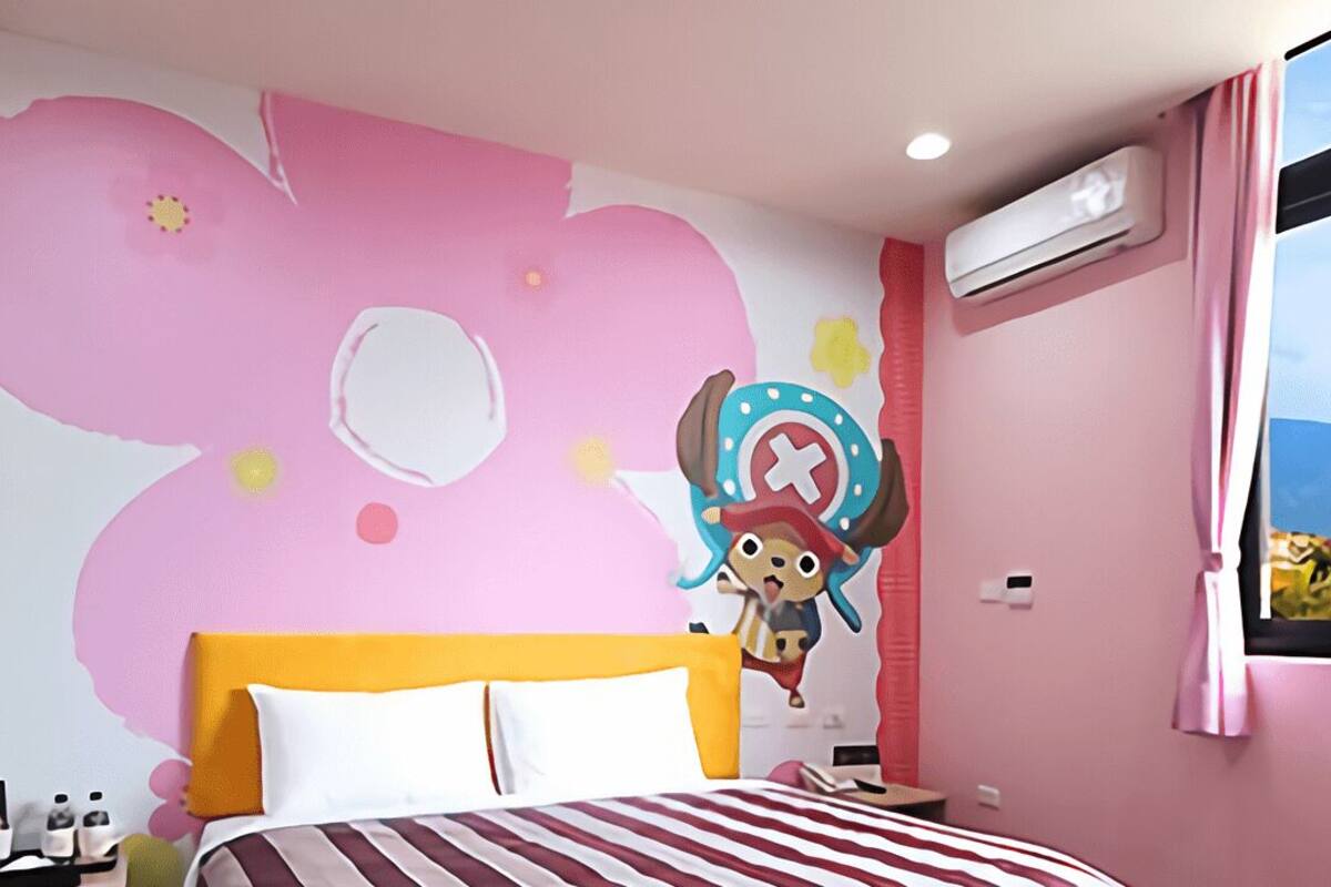 A bedroom with a bed, a wall mural, an air conditioning unit, and a window with a view.