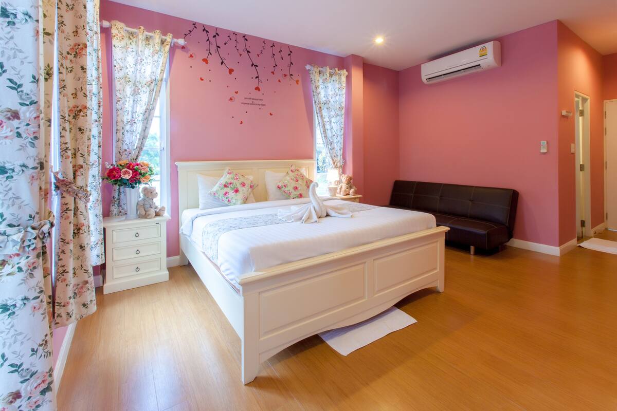A bedroom with a bed, bedside table, and a bench.