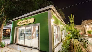 A green building with a sign reading "Green Valley" and large glass doors.