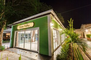 A green building with a sign reading "Green Valley" and large glass doors. - Varee Valley Resort and Restaurant (Ubolratana)