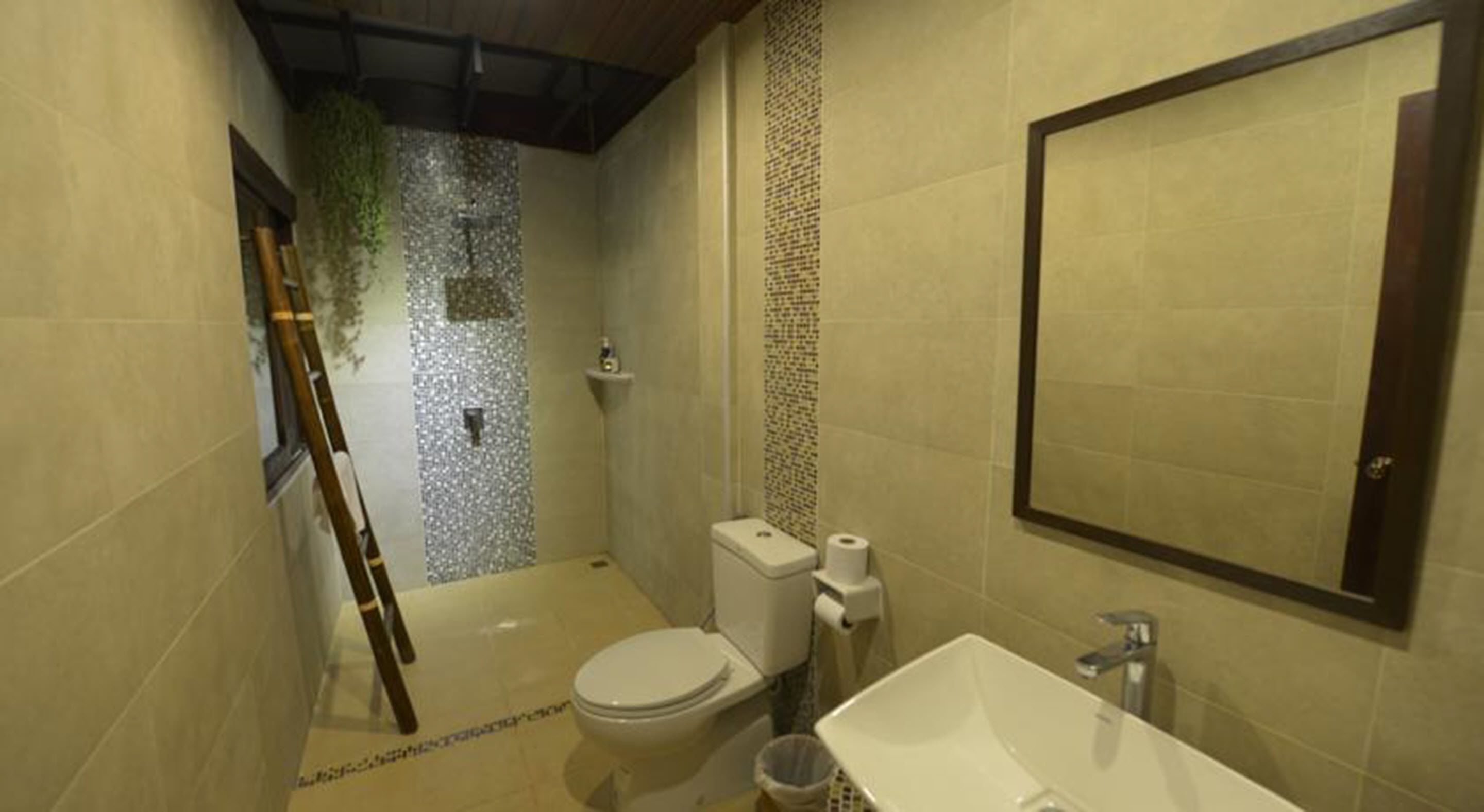 A compact bathroom with a toilet, sink, and shower.