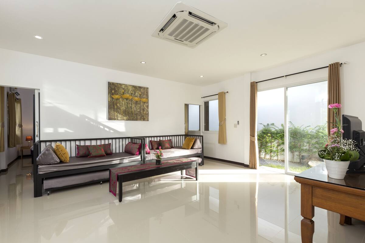 A modern living room with a sofa, a coffee table, and a TV.