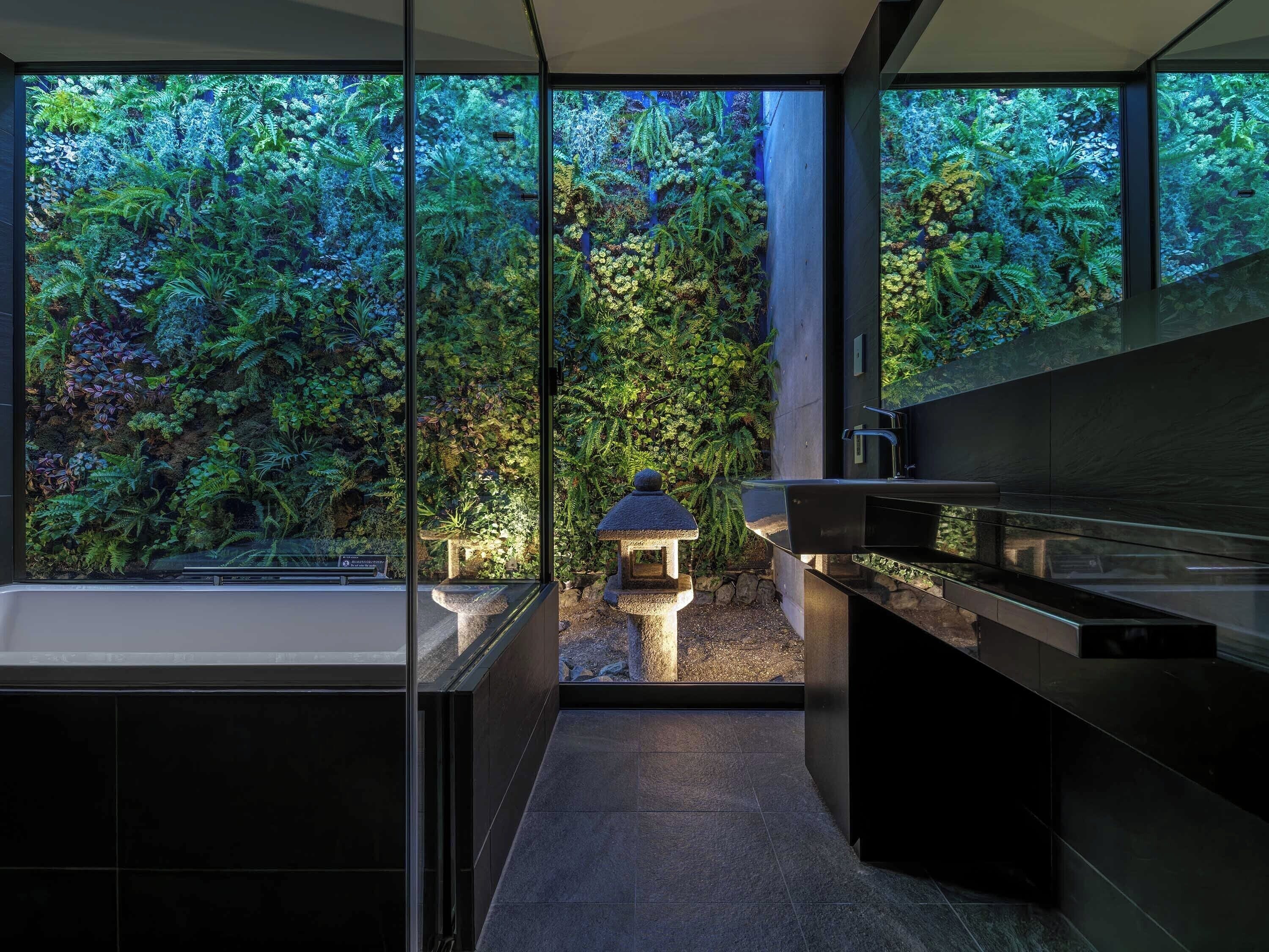 Een moderne badkamer met een groot raam dat uitkijkt op een weelderige tuin.