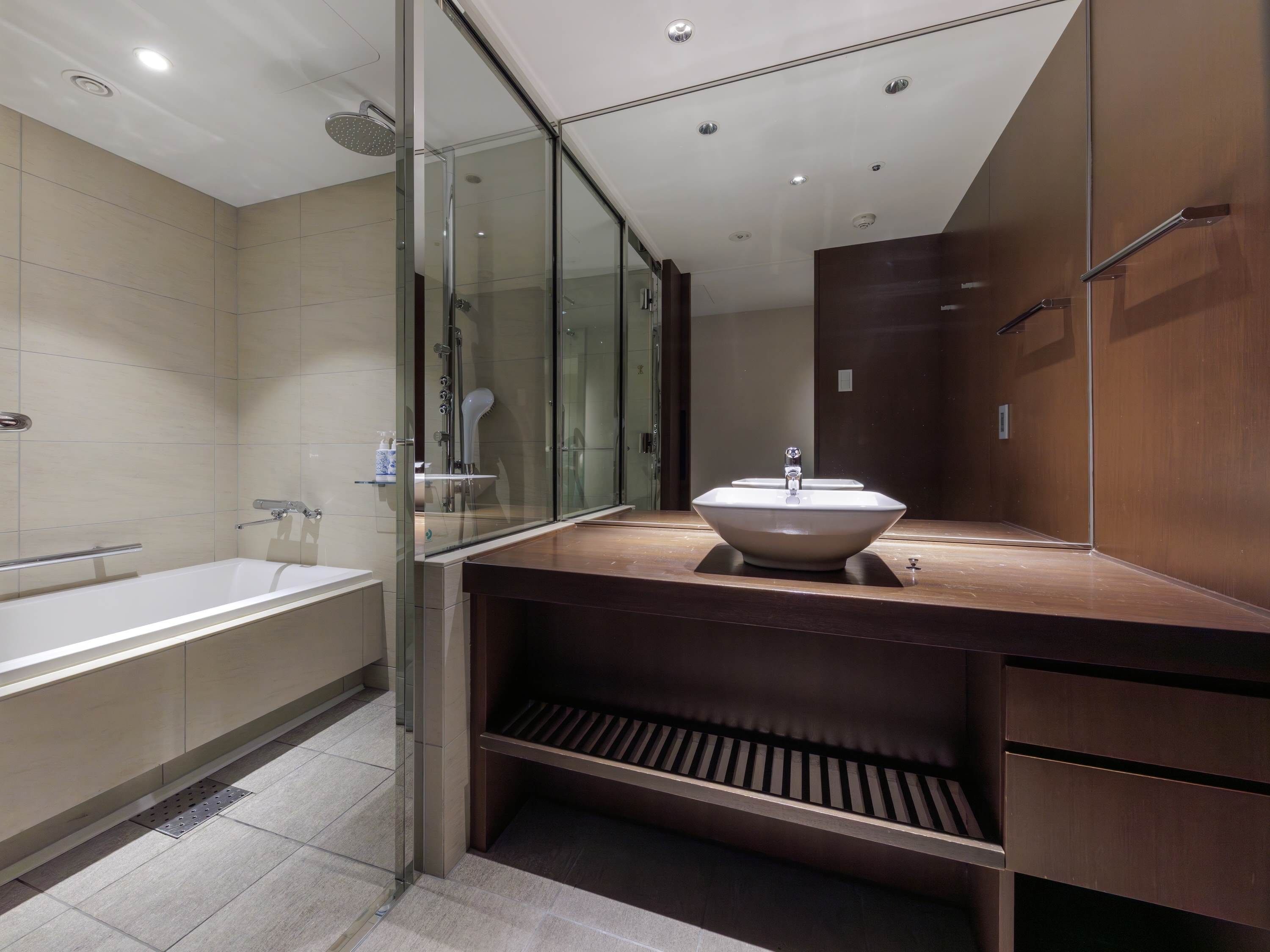 A modern bathroom with a glass-enclosed shower, a freestanding bathtub, and a vanity with a sink.