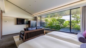 A modern bedroom with a large bed, a seating area with a TV, and a balcony with a view of greenery. - SOLARIA Nishitetsu Hotel Kyoto Premier (Kyoto)