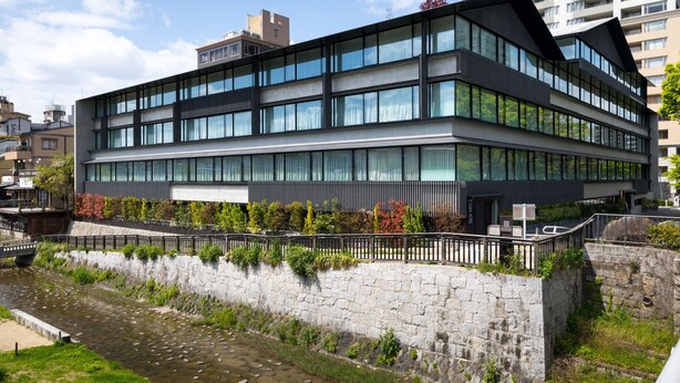 A modern multi-story building with large windows and a stone retaining wall. - SOLARIA Nishitetsu Hotel Kyoto Premier (Kyoto)