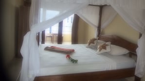 Uma cama com dossel, cabeceira de madeira e almofadas com estampas florais.