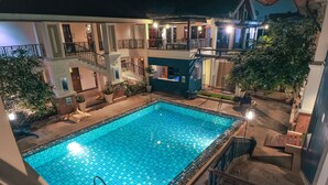A two-story building with a swimming pool, outdoor lighting, and multiple balconies. - Glur Chiangmai (Chiang Mai)