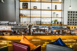 A bar area with a counter, buffet setup, and seating with cushions.