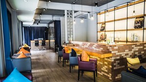 A modern bar area with a brick counter, bar stools, and pendant lighting. - Glur Chiangmai (Chiang Mai)