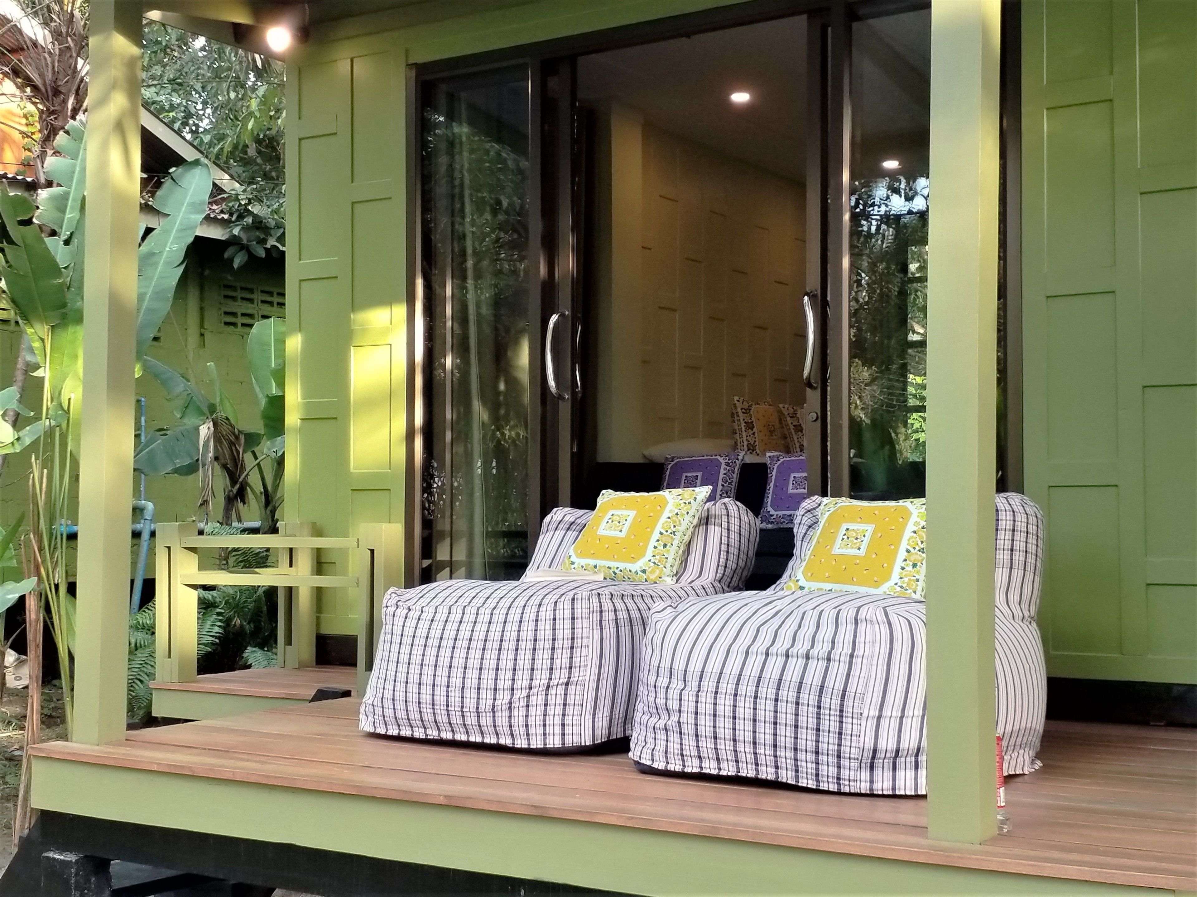 Un espace extérieur accueillant avec une terrasse en bois, une porte-fenêtre coulissante donnant sur une pièce et un banc.